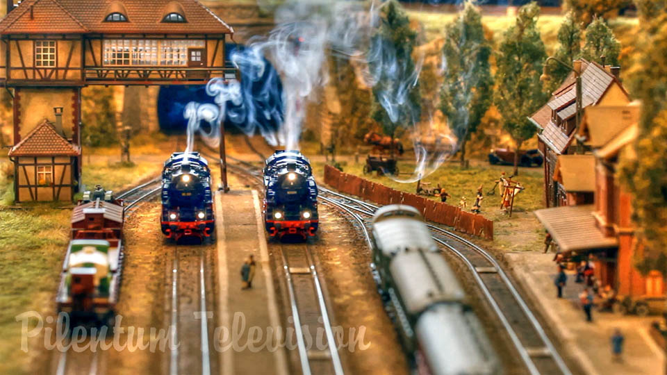 Machetă feroviară la scară HO cu locomotive cu aburi care fumează
